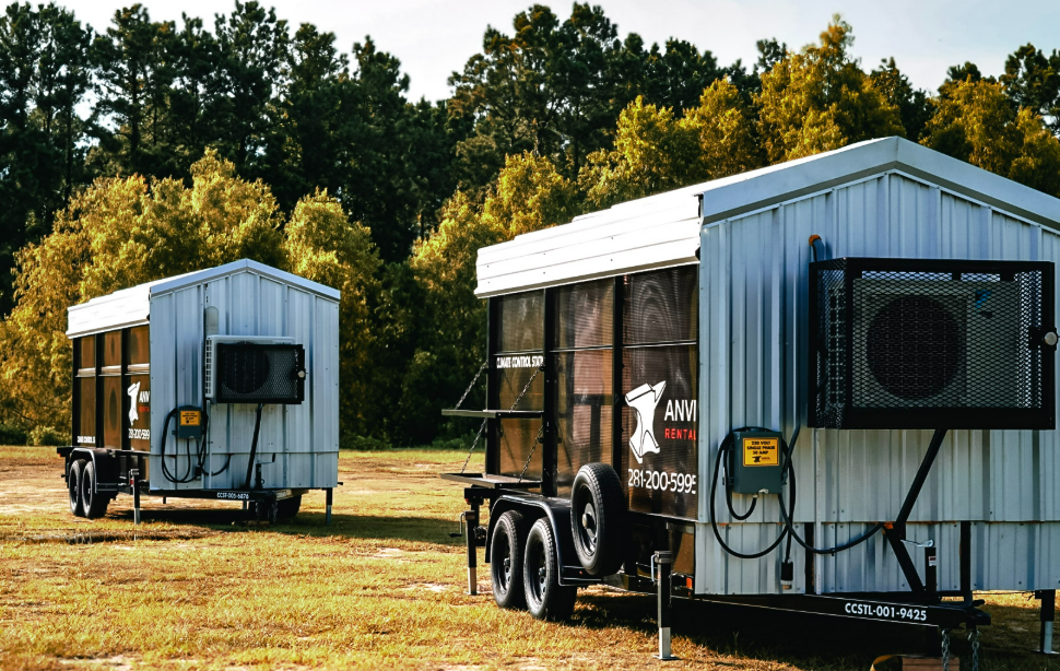Two Anvil Rentals climate control station trailers staged side by side with their exterior air conditioning units running